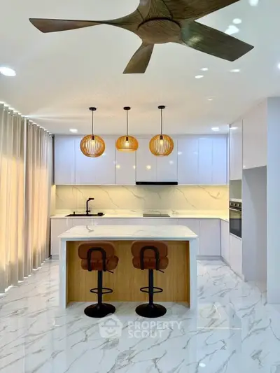 Modern kitchen with marble flooring, island, and stylish pendant lights