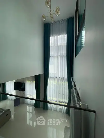 Spacious modern living room with high ceilings and elegant curtains