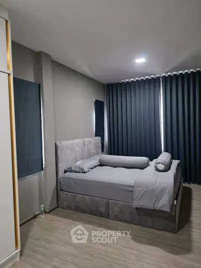 Modern bedroom with stylish gray decor and floor-to-ceiling curtains