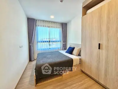Modern bedroom with large window and wooden wardrobe, offering a cozy and inviting atmosphere.