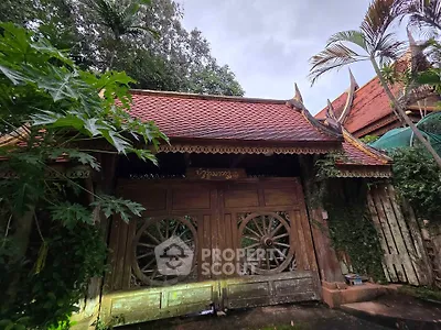 Charming traditional wooden house with ornate roof and lush greenery
