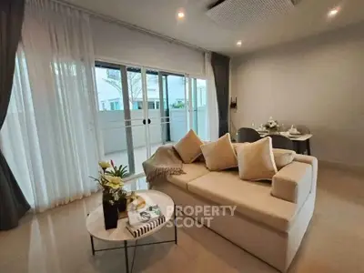 Spacious living room with modern decor and large sliding glass doors leading to a balcony.