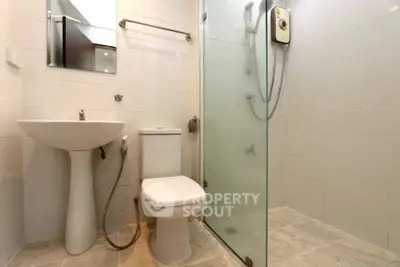 Modern bathroom with glass shower and sleek fixtures in a contemporary home.