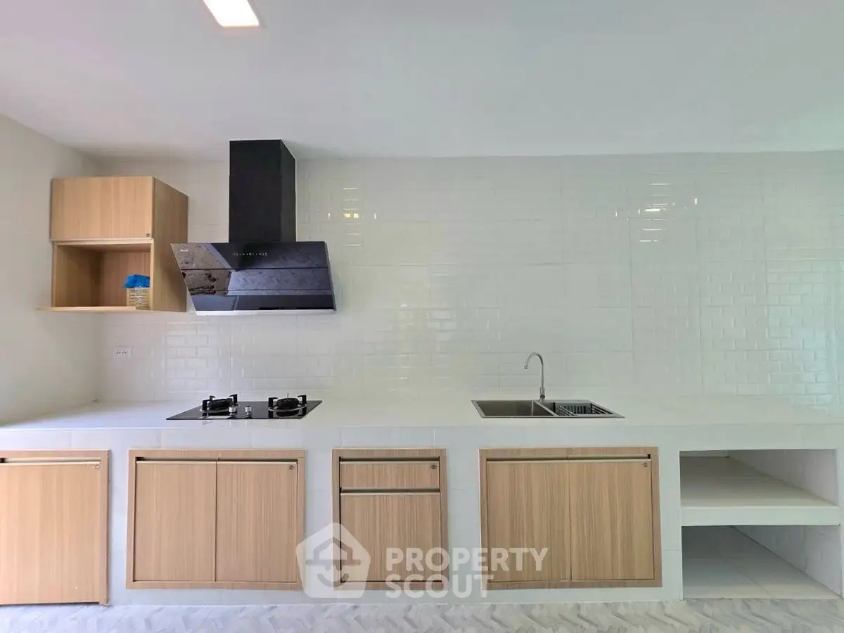 Modern kitchen with sleek cabinetry and gas stove in minimalist design.