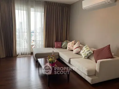 Spacious living room with modern sofa and city view, perfect for relaxation and entertaining.