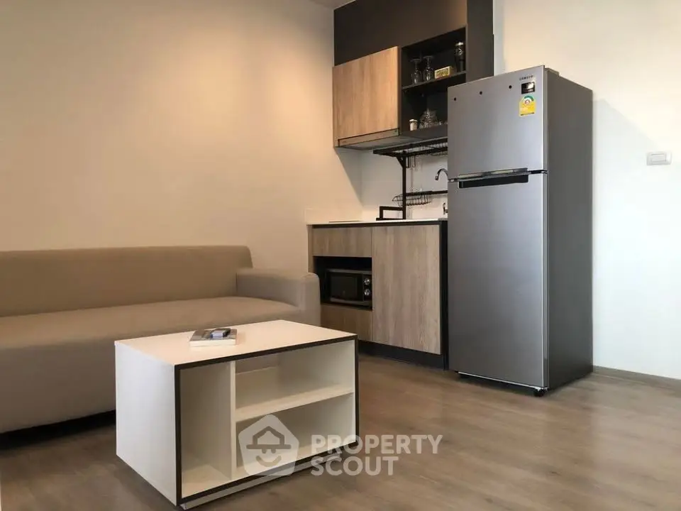 Modern studio apartment with compact kitchen and cozy living area, featuring sleek appliances and minimalist design.