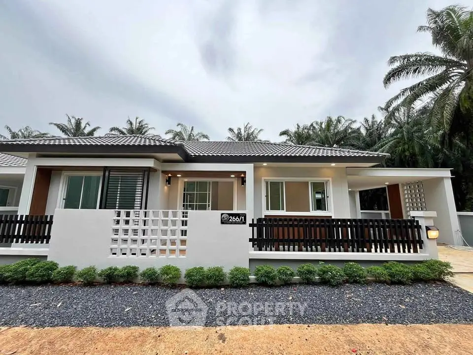 Modern single-story house with sleek design and lush surroundings, perfect for serene living.