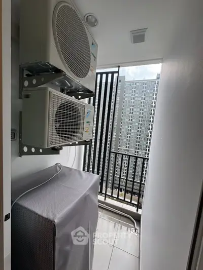 Modern apartment balcony with air conditioning units and city view