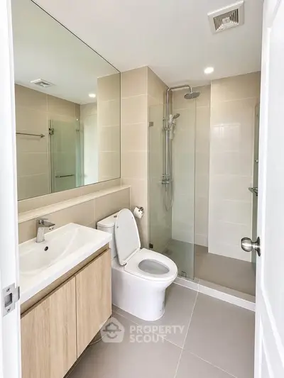 Modern bathroom with glass shower and sleek fixtures in a contemporary apartment.