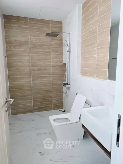 Modern bathroom with sleek fixtures and elegant tile design, featuring a spacious shower and contemporary sink.