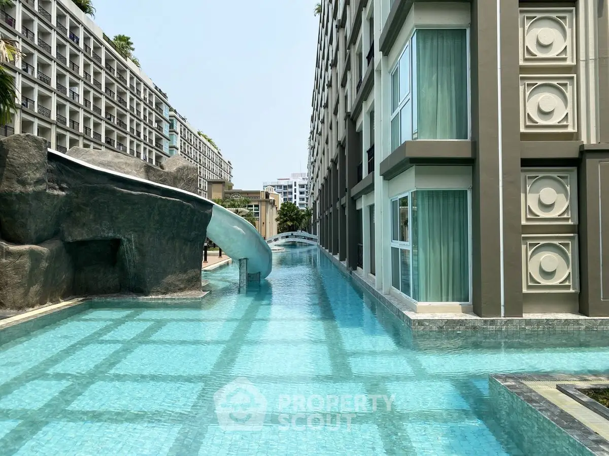 Luxurious apartment complex with stunning pool and water slide feature.