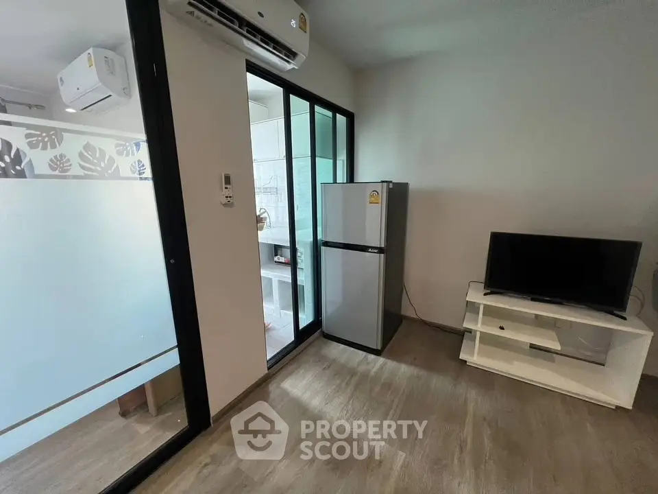 Modern apartment interior with sleek kitchen and living area featuring air conditioning and stylish decor.