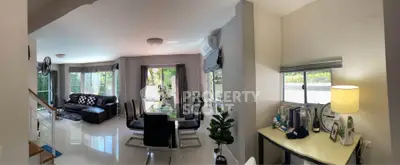 Spacious modern living room with dining area and study nook, featuring large windows and stylish decor.