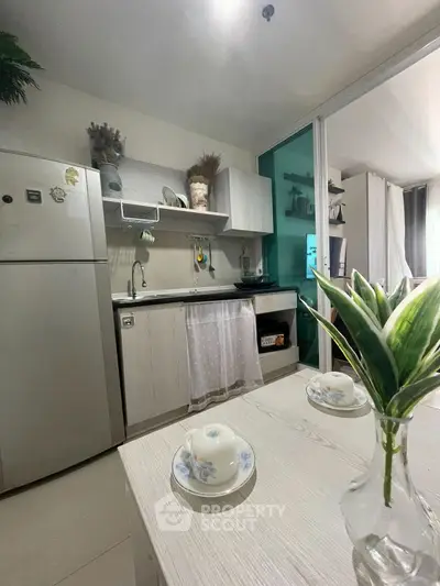 Charming kitchen with modern appliances and cozy dining area in stylish apartment.