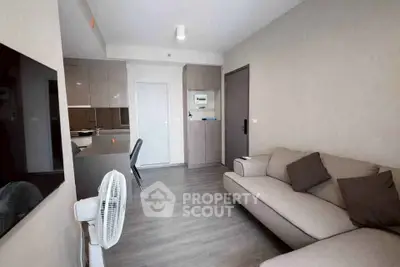 Modern living room with sleek furniture and open kitchen layout in a stylish apartment.