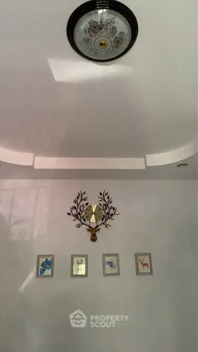 Elegant wall decor with framed art and ornate clock in stylish interior.