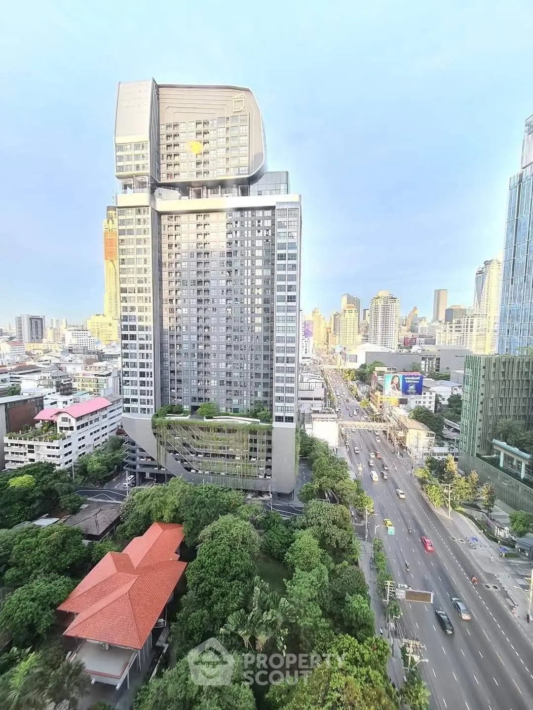 Stunning cityscape view featuring modern high-rise building and lush greenery.