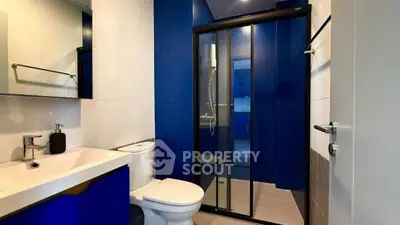Modern bathroom with sleek blue accents and glass shower enclosure