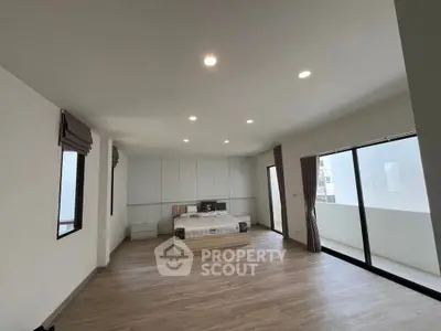 Spacious modern bedroom with large windows and balcony access