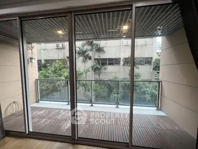 Spacious balcony with wooden flooring and lush greenery view