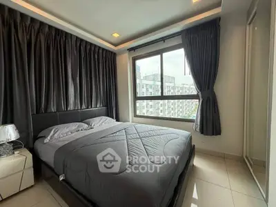 Modern bedroom with large window and stylish decor in urban apartment.
