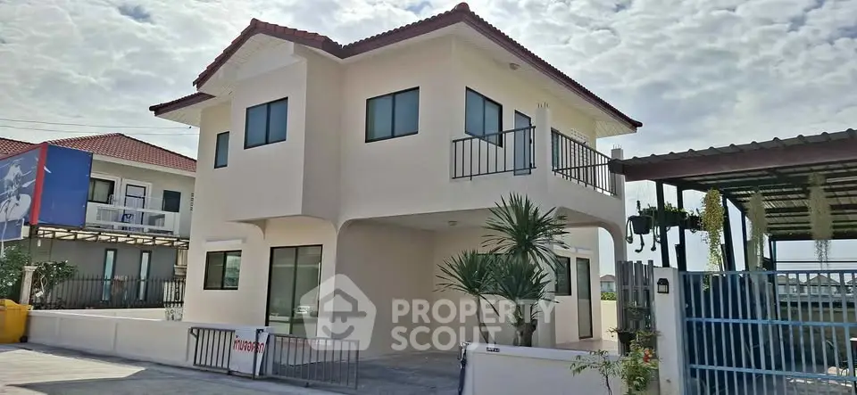 Modern two-story house with red-tiled roof and spacious driveway in a sunny neighborhood.