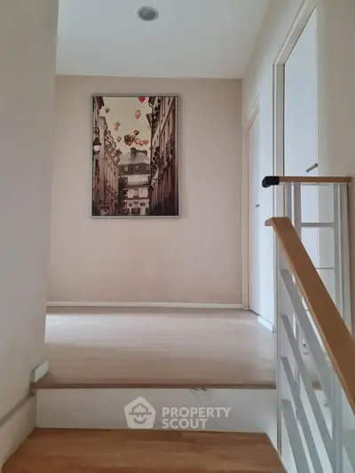 Modern hallway with elegant artwork and wooden flooring