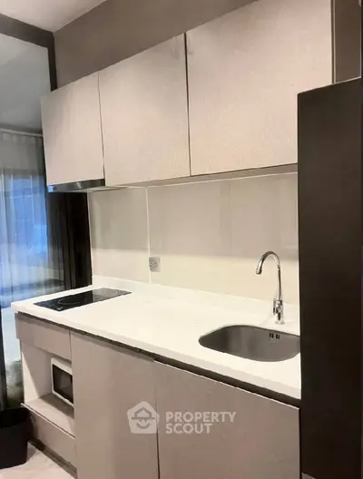 Modern compact kitchen with sleek cabinetry and integrated appliances.