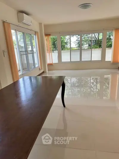 Spacious living room with large windows and natural light, perfect for modern living.