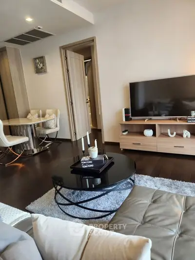 Modern living room with stylish furniture and sleek decor, featuring a cozy seating area and a flat-screen TV.