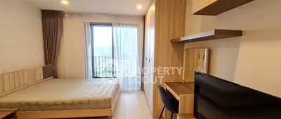 Modern bedroom with balcony view, featuring stylish furniture and ample natural light.