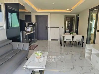 Modern open-plan living and dining area with sleek furniture and marble flooring.