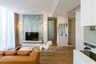 Modern living room with stylish decor and open kitchen layout, featuring a cozy seating area and natural light.