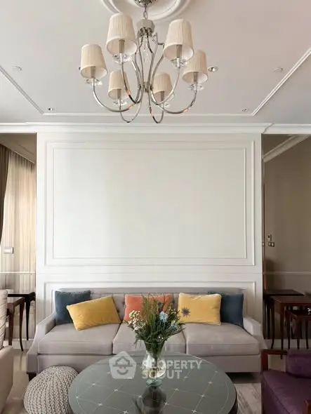 Elegant living room with chandelier, cozy sofa, and stylish decor