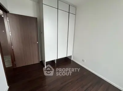 Minimalist bedroom with sleek wooden flooring and built-in wardrobe