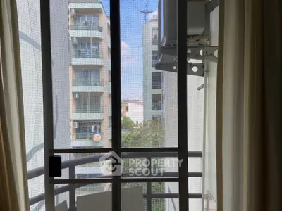 Modern apartment balcony view with nearby buildings and clear sky