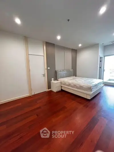 Spacious bedroom with wooden flooring and modern design