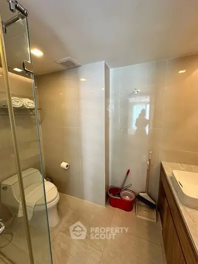Modern bathroom with glass shower, sleek tiles, and elegant fixtures in a contemporary home.