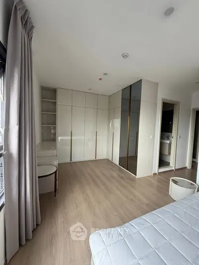 Spacious bedroom with modern wardrobe and large window view