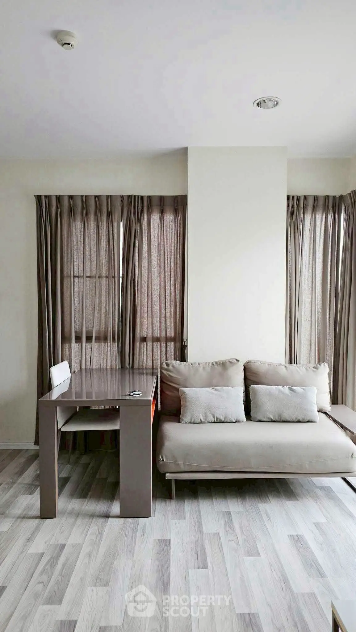 Modern living room with sleek sofa and stylish table, featuring elegant floor-to-ceiling curtains.