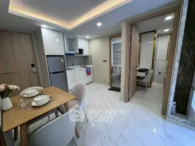 Modern apartment with open kitchen and dining area, featuring sleek design and contemporary furnishings.