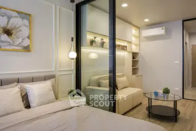 Modern bedroom with sliding glass doors and cozy living area, featuring elegant decor and ambient lighting.