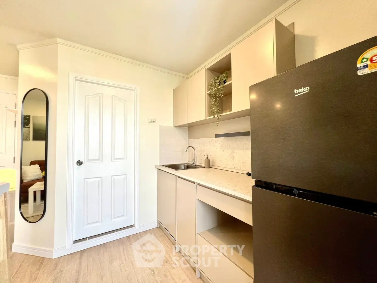 Modern kitchen with sleek black fridge and minimalist design