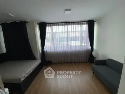 Spacious bedroom with large window and modern furnishings