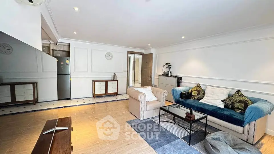 Spacious living room with modern decor and open kitchen layout, perfect for entertaining.