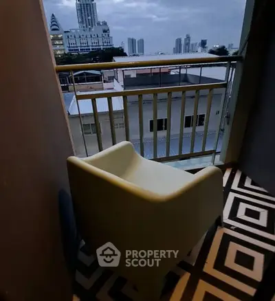 Cozy balcony with city view and modern chair, perfect for relaxation.