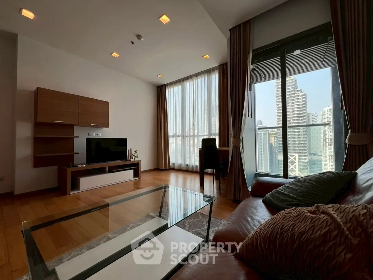 Spacious living room with city view, modern furniture, and floor-to-ceiling windows.