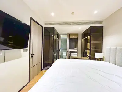 Modern bedroom with ensuite bathroom and sleek glass wardrobe doors