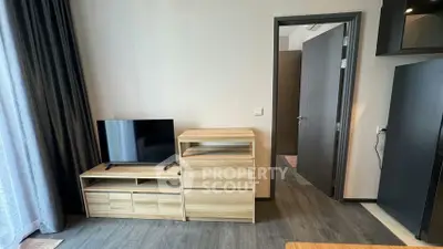 Modern living room with sleek wooden furniture and flat-screen TV, featuring elegant flooring and neutral tones.