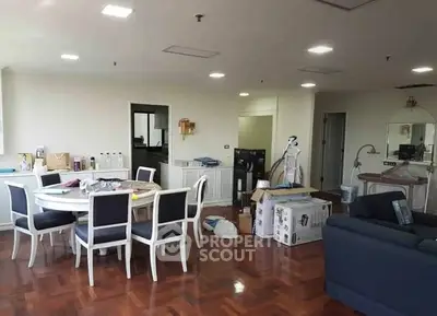 Spacious living room with dining area and hardwood floors in modern apartment.